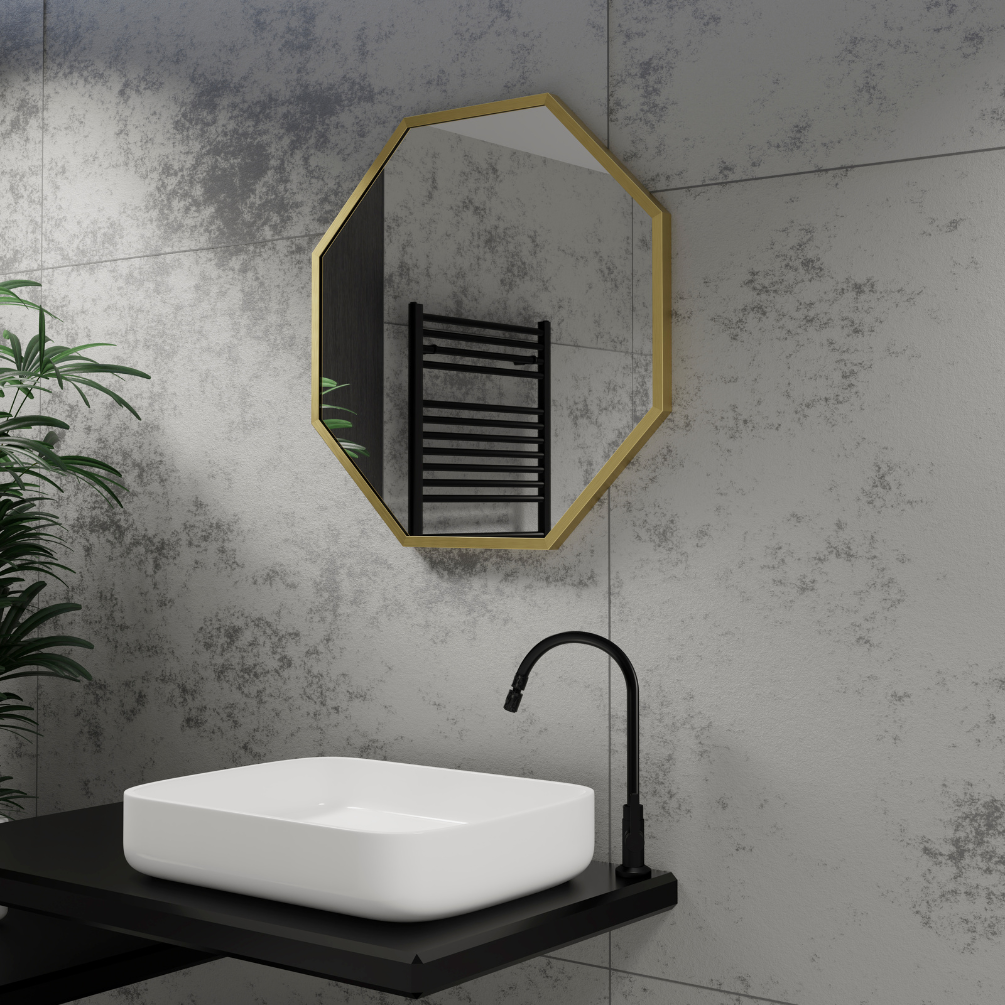 Product Lifestyle image of the Origins Living Docklands 600mm x 600mm Brushed Brass Octagon Mirror mounted on a grey stone wall, in-front of a white rectangular basin. DKL-00T060-BB